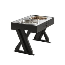 Load image into Gallery viewer, Stylish black pet feeding station with two stainless steel bowls, featuring paw print design and a sturdy X-shaped support that can be adjusted according to the pet&#39;s growth
